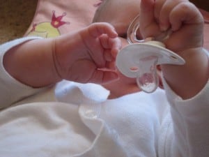 baby playing with dummy