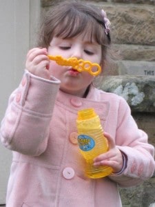 girl blowing bubbles