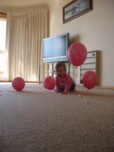 Baby girl among balloons