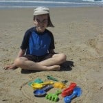 boy on the beach with beach toys