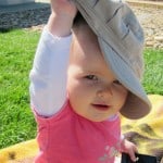 baby with adult hat on head